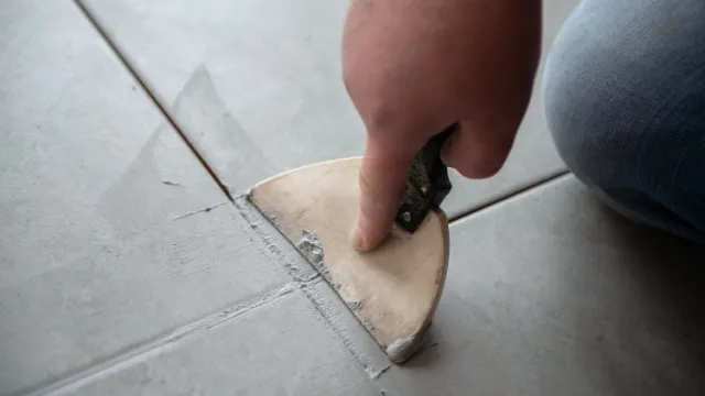 man grouting floor tiles