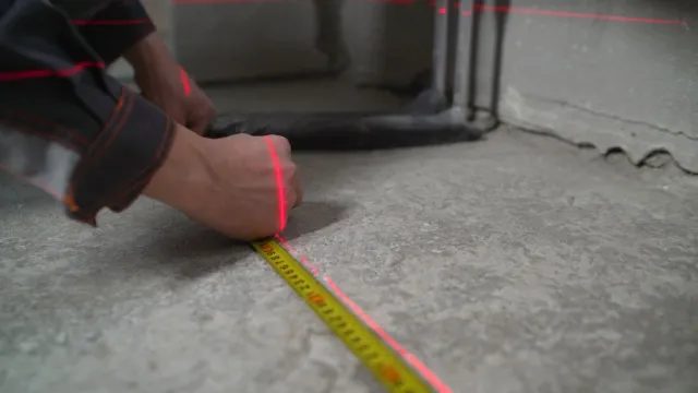 man measuring concrete floor