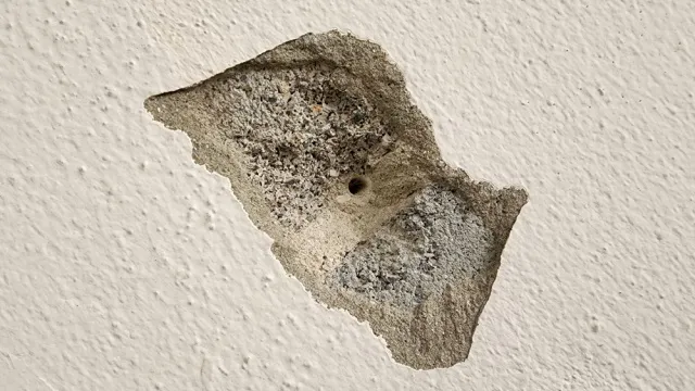 drill hole in damaged plaster