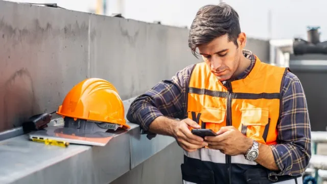 builder looks on smartphone