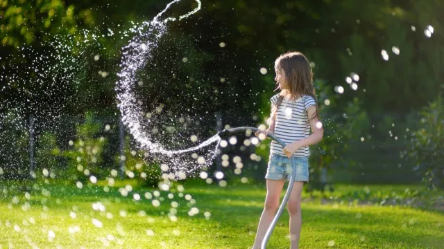 young girl watering lawn
