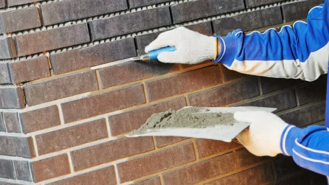man pointing brick wall