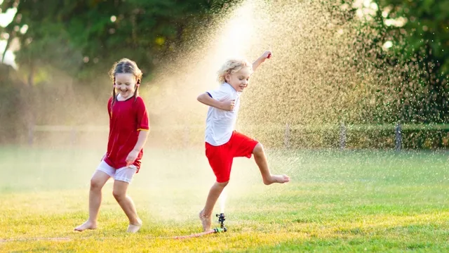 children playing with garden sprinkler