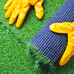 man with work gloves rolls out artificial grass