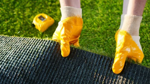 man lays artificial grass