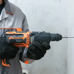 man drills in concrete with a hammer drill
