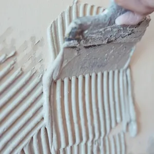 Spreading tile adhesive