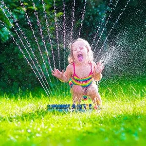 child plays with garden sprinkler